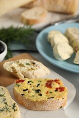 Different types of tasty butter and bread on table, closeup