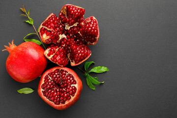 Fresh ripe pomegranates and leaves on grey background, top view. Space for text