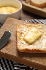 Melting butter, toast and knife on table, closeup