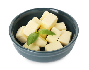 Tasty butter cubes and basil leaves in bowl isolated on white