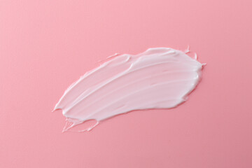 Sample of body care cream on pink background, top view