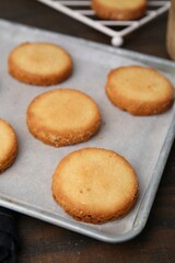 Tray with tasty sweet sugar cookies on wooden table, closeup