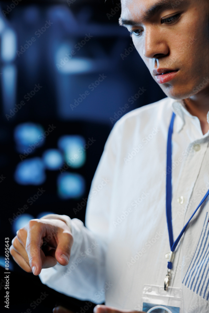 Poster engineer in data center using tablet to prevent system overload during peak traffic periods. employe