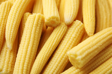 Tasty fresh yellow baby corns as background, closeup