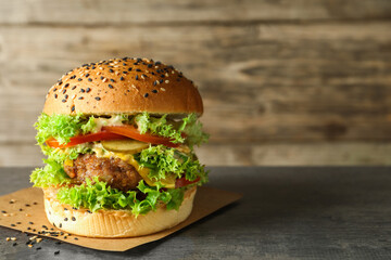 Burger with delicious patty on gray table, space for text