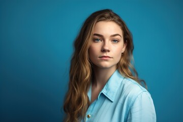 Fototapeta premium A woman with long blonde hair is wearing a blue shirt