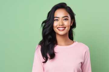 Fototapeta premium A woman with long hair is smiling and wearing a pink shirt