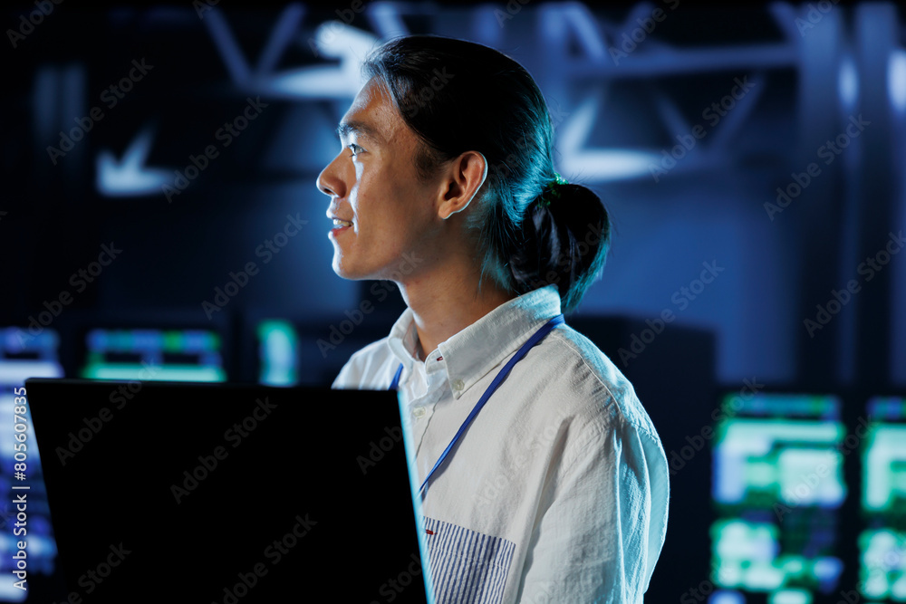 Poster cheerful bipoc man between server hub rows providing processing resources for businesses worldwide. 