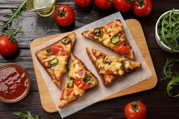 Tasty pizza toasts and ingredients on wooden table, flat lay