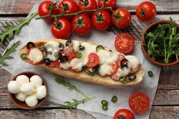 Tasty pizza toast and ingredients on wooden table, top view