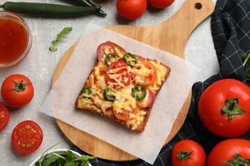 Tasty pizza toasts and ingredients on grey table, flat lay
