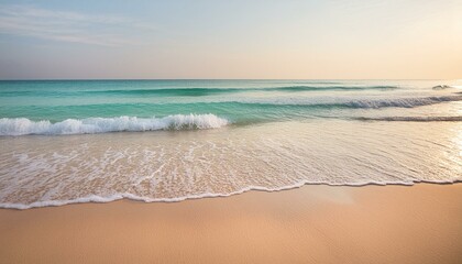 A smooth sandy beach with clear turquoise waters, small gentle waves, under a pale blue sky 