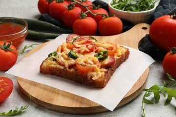 Tasty pizza toast, tomatoes and sauce on grey table