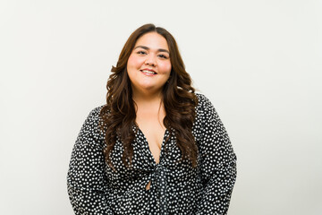 Radiant plus-size woman smiling on a studio with white background