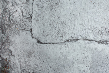 Imagen horizontal de una pared de cemento con grietas viejas y desgastadas ideal para fondos
