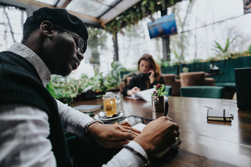 Young entrepreneurs collaborating in a stylish urban coffee shop setting.