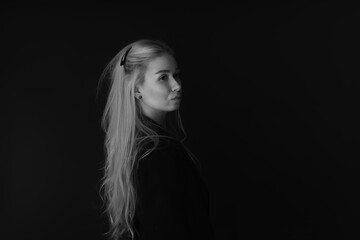 Black and white low key portrait of beautiful young blonde woman