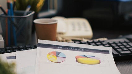 Cup of coffee and paperwork on office desk containing company profit analysis, close up shot. Business documents, hot beverage and telephone on table in accounting workplace