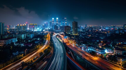 Night cityscape with light trails on highways in modern urban setting.