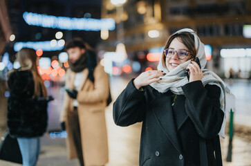 Smiling young woman enjoying a winter evening outdoors in the city.