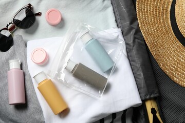 Cosmetic travel kit, plastic bag and accessories in suitcase, top view