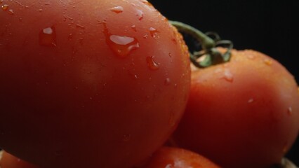 Macrography, tomatoes nestled within a rustic wooden basket are showcased against a dramatic black...