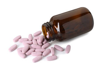 Scattered vitamin pills and bottle isolated on white