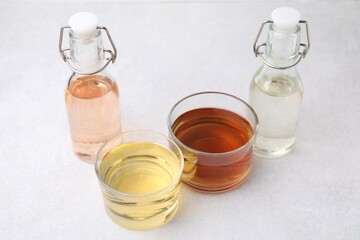 Different types of vinegar on light table, closeup