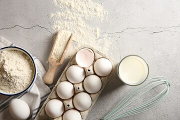 Making dough. Flour, eggs, milk and tools on light textured table, flat lay