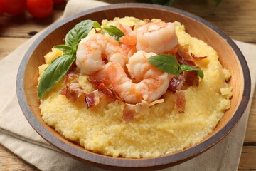 Fresh tasty shrimps, bacon, grits and basil in bowl on table, closeup