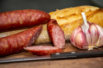 Rustic bread with salami and garlic on wooden board