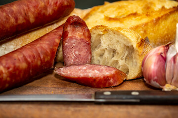 Rustic bread with salami and garlic on wooden board