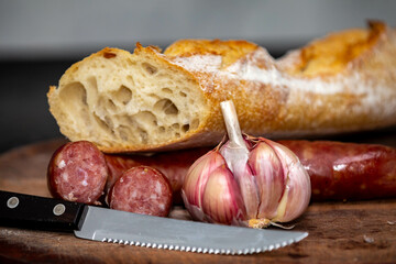 Rustic bread with salami and garlic on wooden board