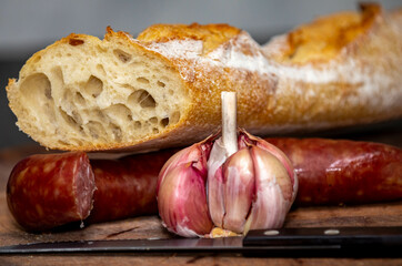 Rustic bread with salami and garlic on wooden board