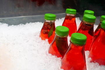 Healthy fresh juice in plastic bottles freeeze in ice
