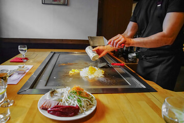 chef's hands with spatula over teppanyaki. Teppan show