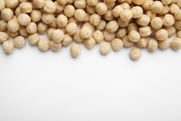 Tasty cereal balls on white background, flat lay