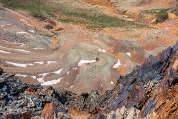Scenic dizzy top-down view from precipice edge with sharp rocks to unusual multicolor stony valley...