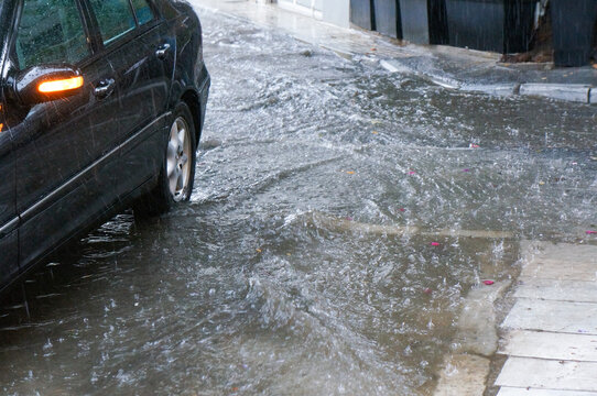大雨で浸水し始める街中のとある道路