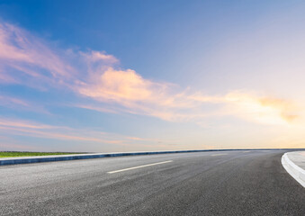 Modern highway cutting through Asian countryside under a clear blue sky