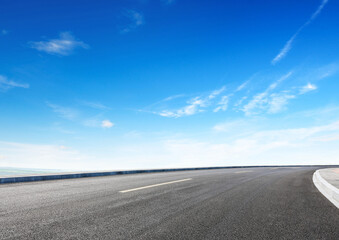 Modern highway cutting through Asian countryside under a clear blue sky