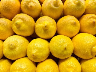 close-up of yellow lemons stacked on the display of an organic producer
