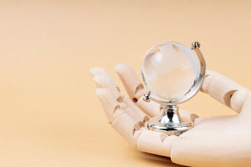 Glass Globe in Cyborg's Palm on Beige Background, Concept of Technological Protection from...