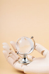 Glass Globe in Cyborg's Palm on Beige Background, Concept of Technological Protection from Environmental Disasters