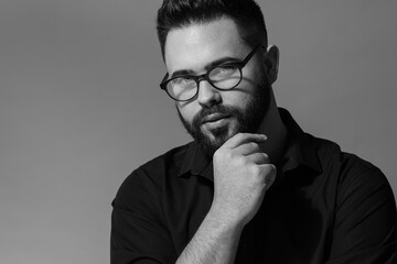 Portrait of handsome bearded man on grey background. Black and white effect