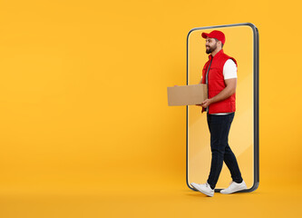 Courier with parcel walking out from huge smartphone on orange background. Delivery service. Space...