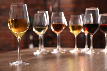 Fototapeta premium Different tasty wines in glasses on wooden table