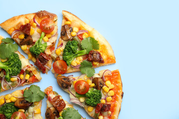 Delicious vegetarian pizza with mushrooms, vegetables and parsley on light blue background, top...