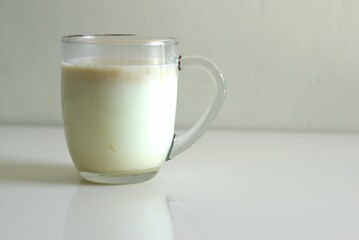 A glass of cereal in milk, transparent glass cup of cereal milk for breakfast with copy space area