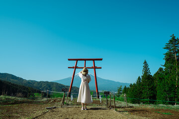 富士山をまつる神社でお参りする女性